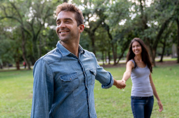 istock Happy man holding hands with his partner at the park 1136817963