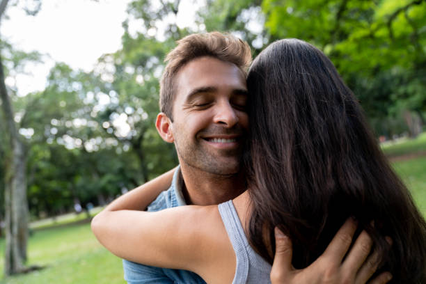 istock Man in love hugging his girlfriend at the park 1136817993