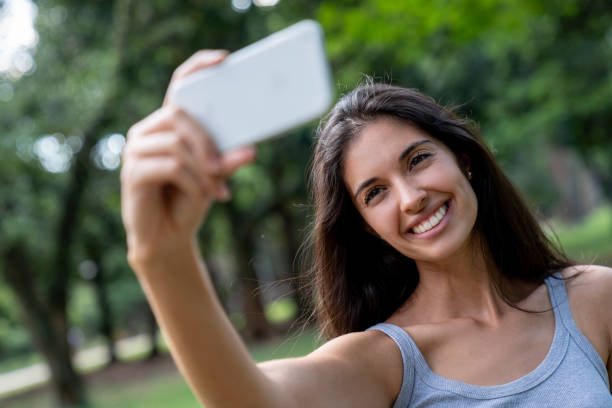 istock Happy woman taking a selfie at the park 1136817996