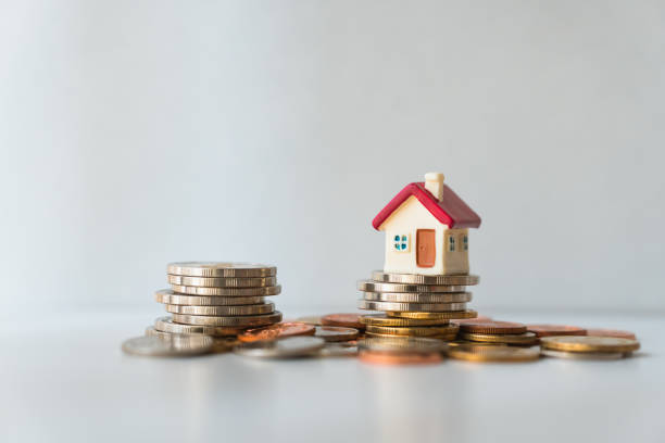 Miniature house above a stack of coin