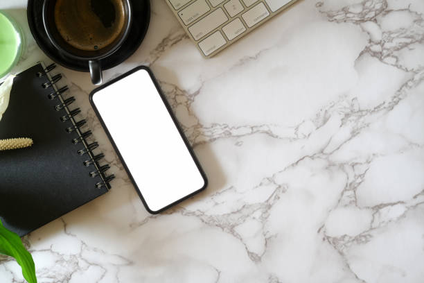 istock Mock up blank screen mobile phone on marble office desk 1136820715