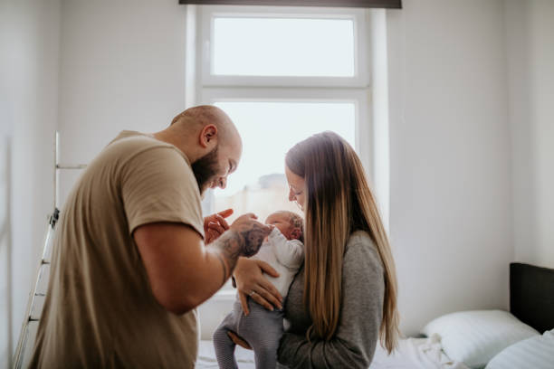 mère et père jouant avec le bébé nouveau-né - baby carrier photos photos et images de collection