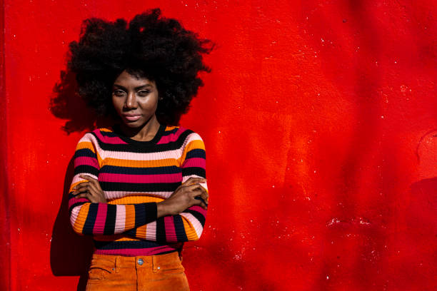istock Woman standing arms crossed on red background 1136823936