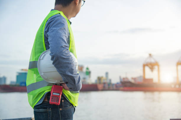 istock Young engineering man and safety helmet, radio standing  cargo port. 1136828378
