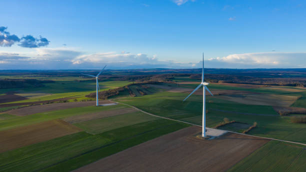 istock Two wind turbines in the middle of the fields at dusk 1136830305