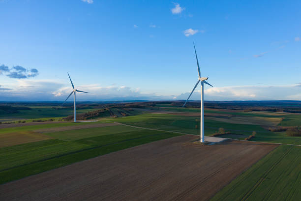 istock Two wind turbines in the middle of the fields at dusk 1136830548