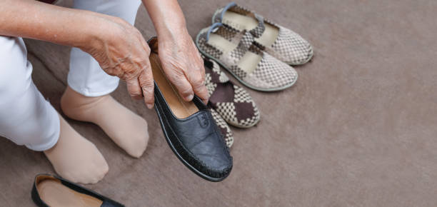 istock Elderly woman putting on shoes 1136831104