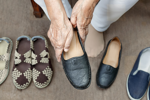 one female summer black leather shoes stands on a white table