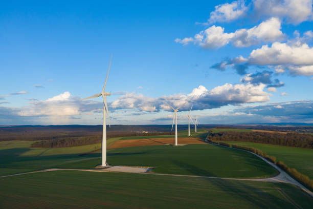 istock Four wind turbines in the middle of the fields at dusk 1136831703