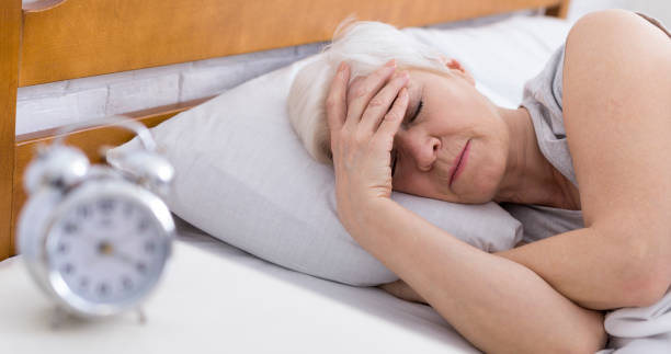 senior woman suffering from insomnia in bed - old senior adult women tired imagens e fotografias de stock