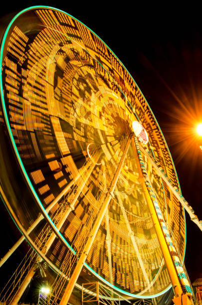 ruota panoramica che gira in fiera di notte a sukhothai - ferris wheel wheel night neon light foto e immagini stock