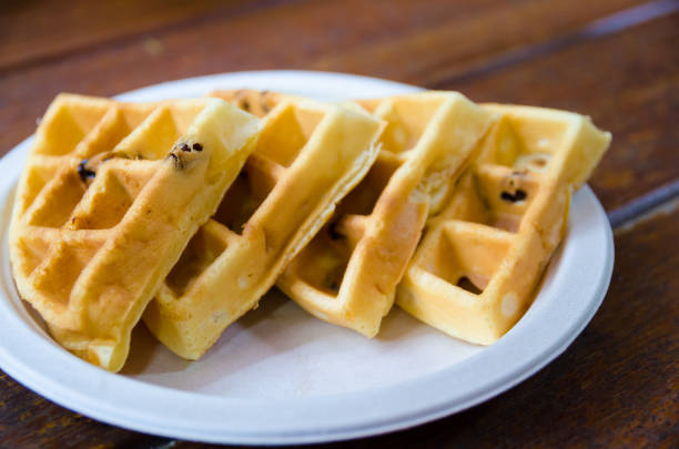 istock four waffles on plate on wooden table, focus on edge of left piece 1136833446