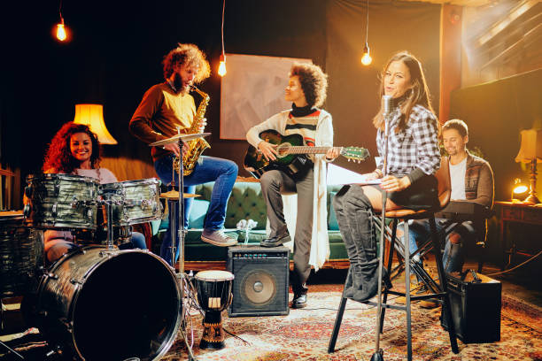 Band practice in home studio. Band practice in home studio. Woman singing while rest of the band playing instruments. performance group photos stock pictures, royalty-free photos & images