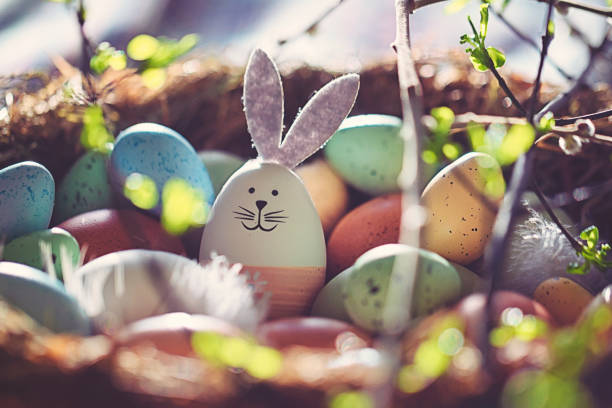 Easter decoration with crafted Easter bunny in the sunny nest stock photo
