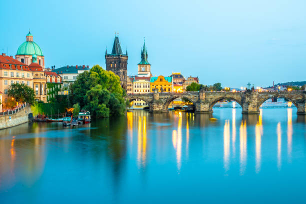 istock Illuminated Charles Bridge reflected in Vltava River. Evening panorama of Prague, Czech Republic. Panoramic shot 1136836131