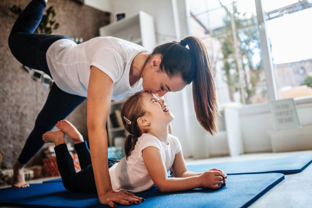 madre e hija trabajando juntos haciendo ejercicio en casa - child yoga gym women fotografías e imágenes de stock