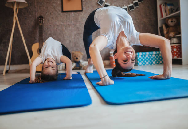 madre e hija trabajando juntos haciendo ejercicio en casa - child yoga gym women fotografías e imágenes de stock