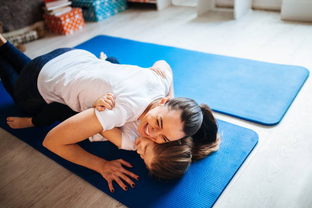 istock Mother and daughter working out together doing exercise at home 1136838260