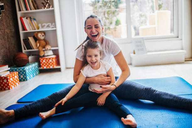 istock Mother and daughter working out together doing exercise at home 1136838588