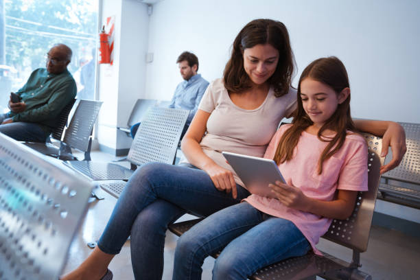 istock Young woman looking at girl using digital tablet 1136838985