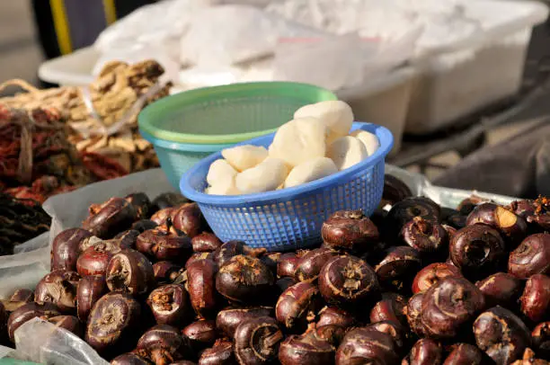 Photo of Water chestnuts being peeled at the market in Asia