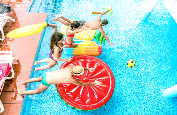 High angle view of millenial friends jumping at swimming pool party - Youth vacation concept with happy guys and girls having fun in summer day at luxury resort - Young people on warm bright filter vista de ángulo alto de los amigos milleniales saltando en la piscina fiesta-concepto de vacaciones de la juventud con chicos y chicas felices divertirse en el día de verano en el complejo de lujo-los jóvenes en caliente filtro brillante