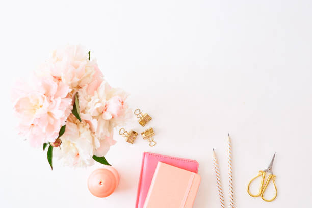 istock Flat lay blogger or freelancer workspace with a notebook and pink peonies on a white background 1136841581