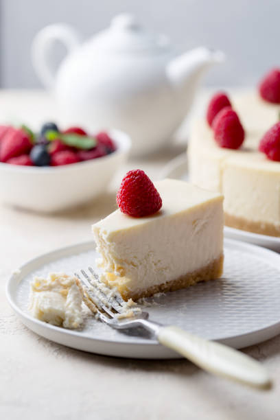istock Piece of birthday cheese cake with raspberry at gray plate on white background 1136842078