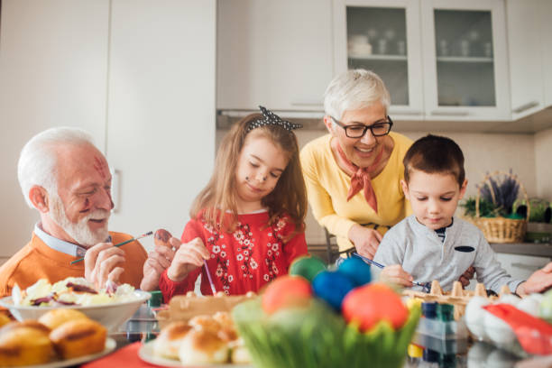 istock Grandparents and children decorating Easter eggs 1136842772