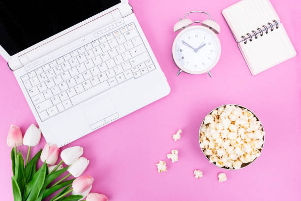 istock Notebook Notepad Alarm Clock Bouquet of tulips Popcorn in a bowl on the desktop 1136844569