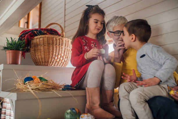 Woman celebrating Easter with grandchildren and giving the Easter eggs for lunch