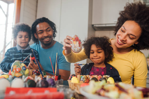 istock Family with children decorating Easter eggs 1136845095