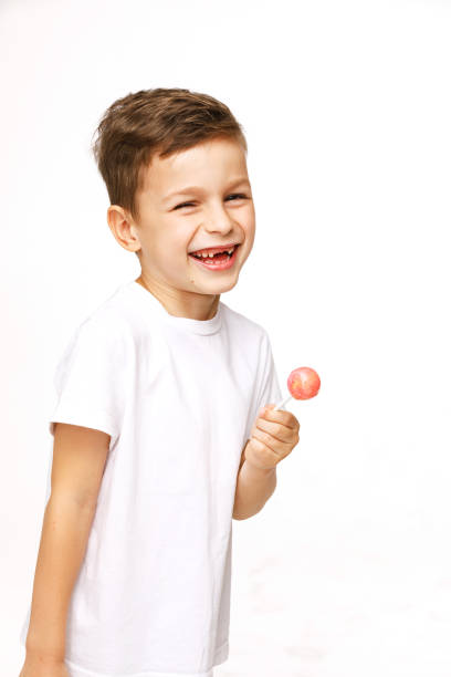 istock little boy with a lollipop on a white background 1136845279