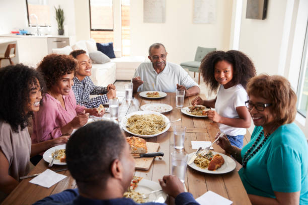 istock Three generation black family sitting at the table talking and eating dinner together, close up 1136847096