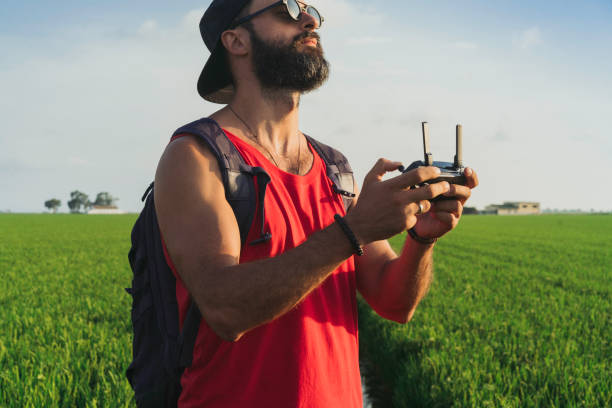 istock Bearded male model use drone remote control to fly device in air. Man operating drone flying in nature. New technologies and innovations concept. 1136847696