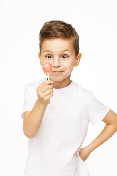 istock little boy with a lollipop on a white background 1136848291