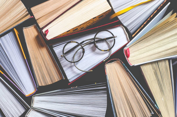istock Lots of colourful thick open books stand on a dark background 1136848566