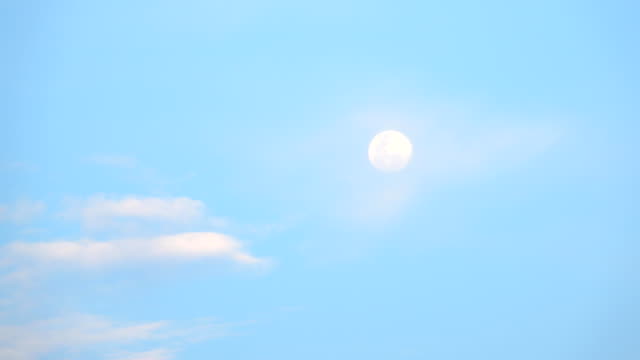 Daytime Moon with passing clouds slowly