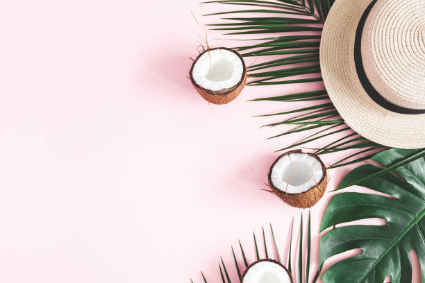istock Summer composition. Tropical palm leaves, hat, coconut on pastel pink background. Summer concept. Flat lay, top view, copy space 1136850455