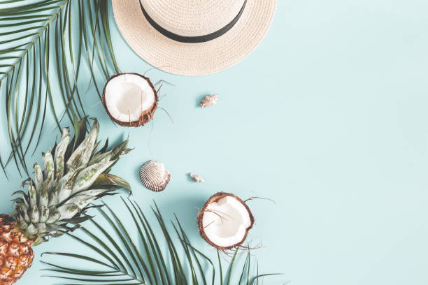 istock Summer composition. Tropical palm leaves, hat, coconut, pineapple on pastel blue background. Summer concept. Flat lay, top view, copy space 1136850694
