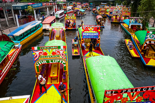 Xochimilco, Mexico City, Mexico - August 3, 2018 : Vendor in a small boat selling food to tourists in a colored boat at Xochimilco