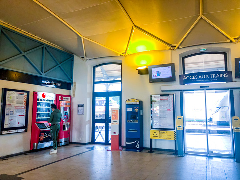 Arcachon, France - May 06, 2018: Arcachon Train station inside. Woman buying tickets in a ticket machine.