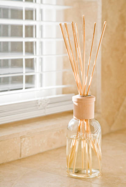 istock Sunlight shining through window blinds onto fragrance diffuser on stone tile bathroom counter. Clean, bright, fresh house home interior decor elements details. 1136852576