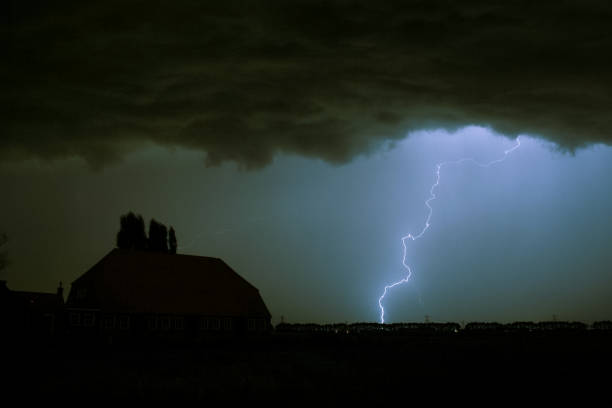 istock Lightning strike with a dark blue sky over a house silhouette. 1136853218