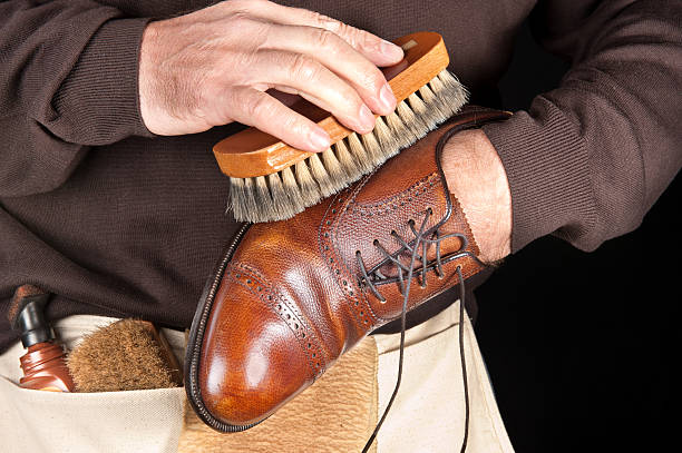 Shoe polisher A shoe shiner works on the final buffing of a leather dress shoe shoe polish stock pictures, royalty-free photos & images