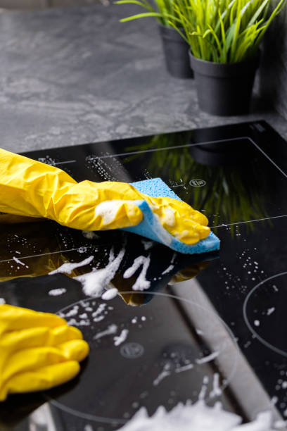 Housekeeping, House Cleaning The girl washes the stove with a blue sponge in yellow gloves cleaning stove domestic kitchen human hand stock pictures, royalty-free photos & images