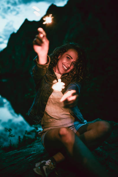 istock Adorable Female Celebrating Life With Lights While Camping 1136855396
