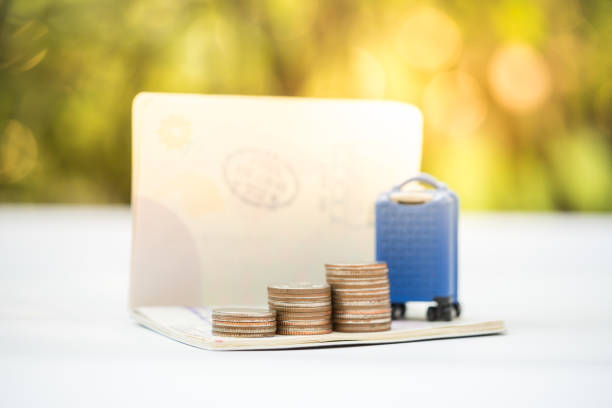 Travel and financial saving concept. Miniature baggage, coins stacks,and passport. stock photo