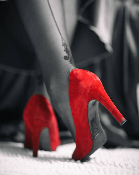 istock Elegant female legs in red shoes 1136856940