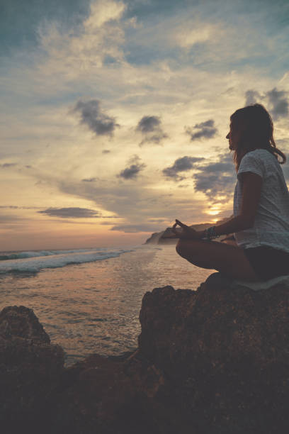 istock Young woman practicing yoga - meditation on the beach. 1136858121